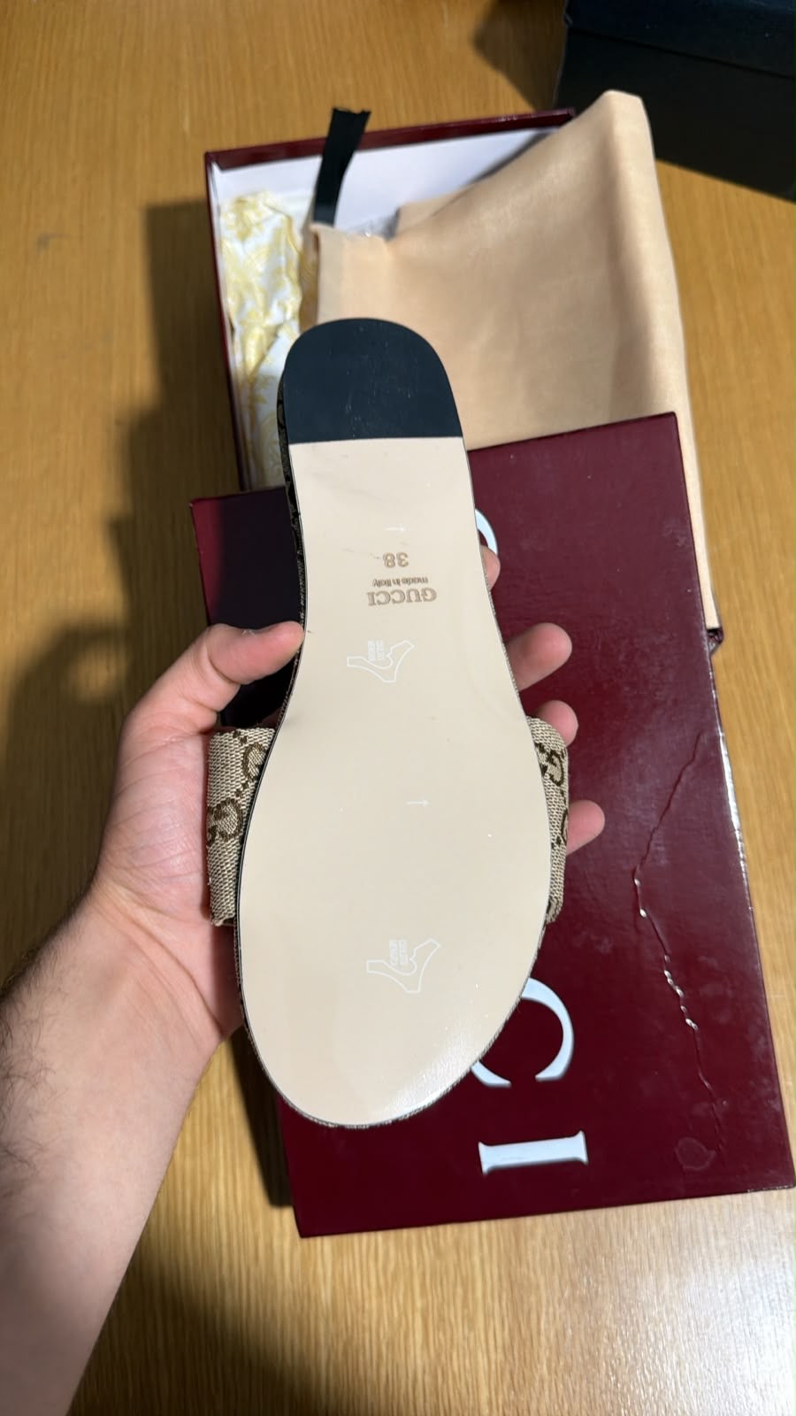 Gucci slide slipper crafted from beige and dark brown GG monogram canvas and finished with a classic gold-toned horsebit detail.