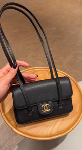 Chanel Preppy Coco Mini Flap Bag in black grained shiny calfskin, featuring dual slender shoulder straps and an iconic gold-tone CC turn-lock.