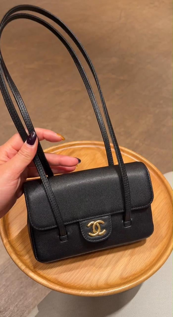 Chanel Preppy Coco Mini Flap Bag in black grained shiny calfskin, featuring dual slender shoulder straps and an iconic gold-tone CC turn-lock.