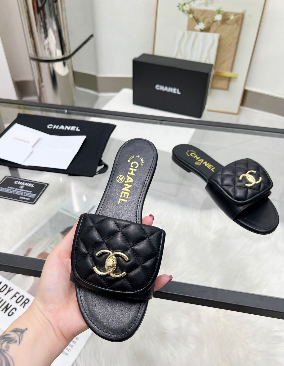 Channel flat slide slipper adorned with the iconic gold-tone Chanel CC logo