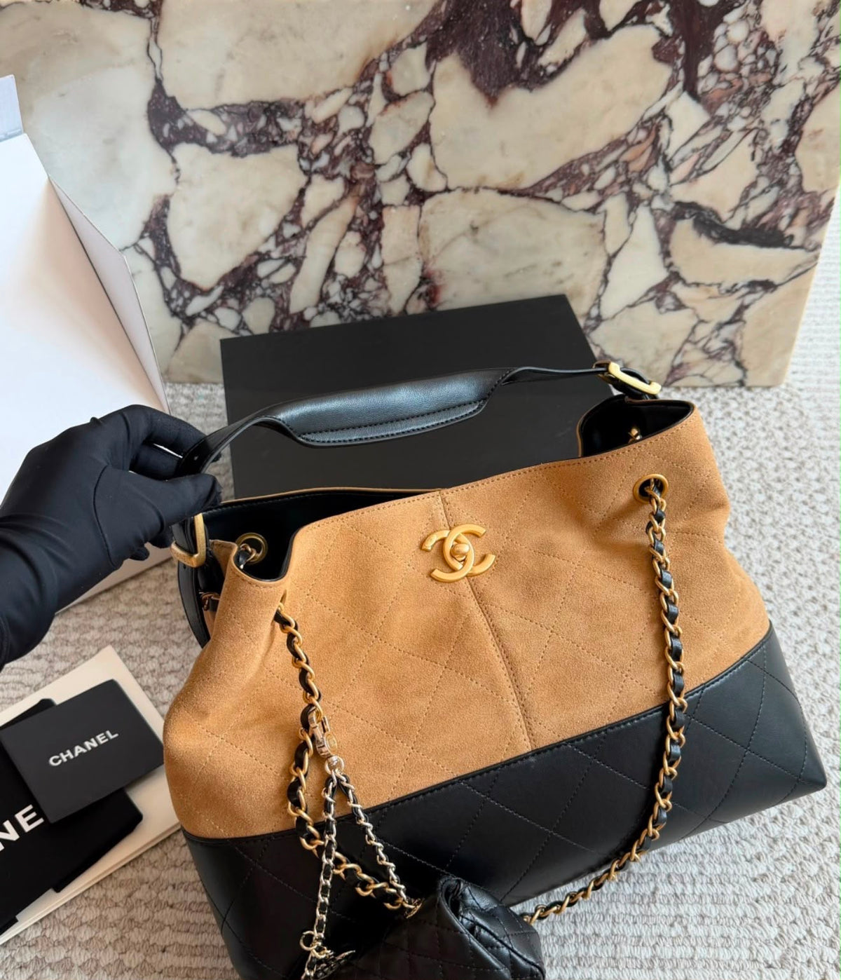 This is the Chanel Small Coco Base Shopping Bag in grey/ camel suede and black lambskin with aged gold-tone hardware