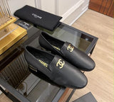 These are black leather Chanel CC logo loafers featuring polished gold-tone interlocking CC hardware on the vamp