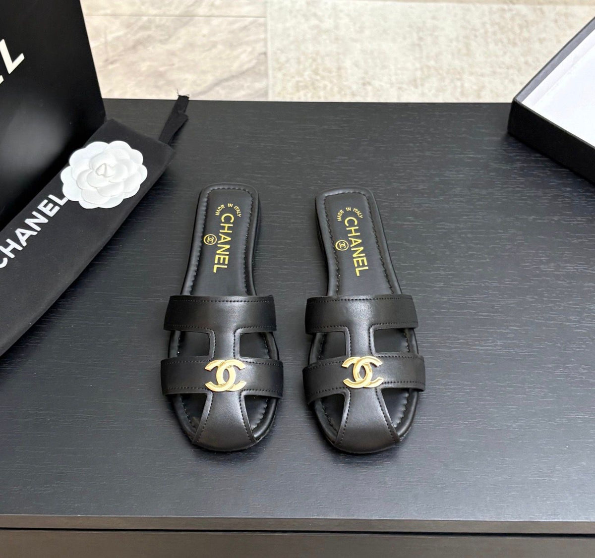 lambskin Chanel flat mules featuring a polished gold-tone CC logo on the cutout strap