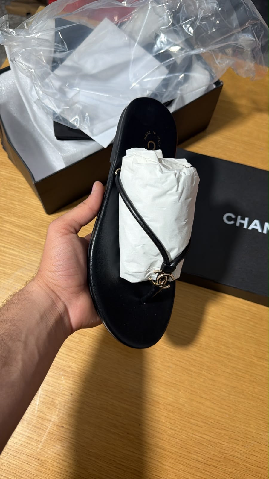 black leather thong slipper featuring a delicate gold-tone interlocking CC logo at the front.