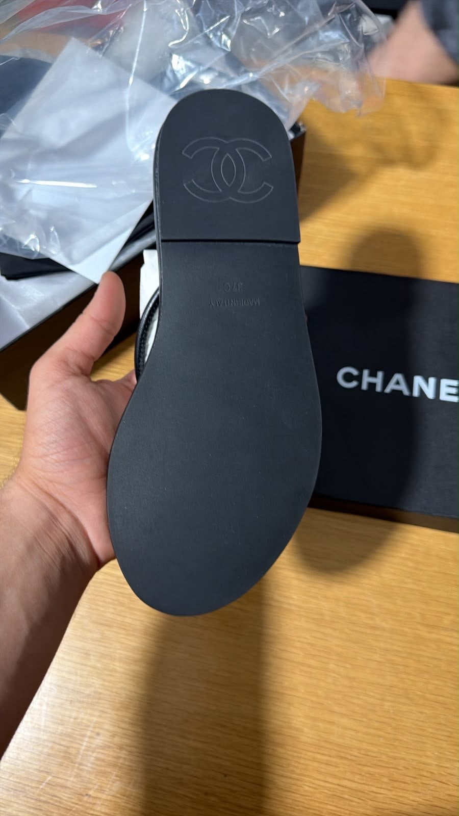 black leather thong slipper featuring a delicate gold-tone interlocking CC logo at the front.