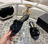 black suede Chanel flat mules featuring double Velcro straps with gold-tone hardware and crystal CC embellishments