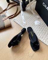 Channel black flat thong sandals featuring a dimensional Camellia flower accent on the strap
