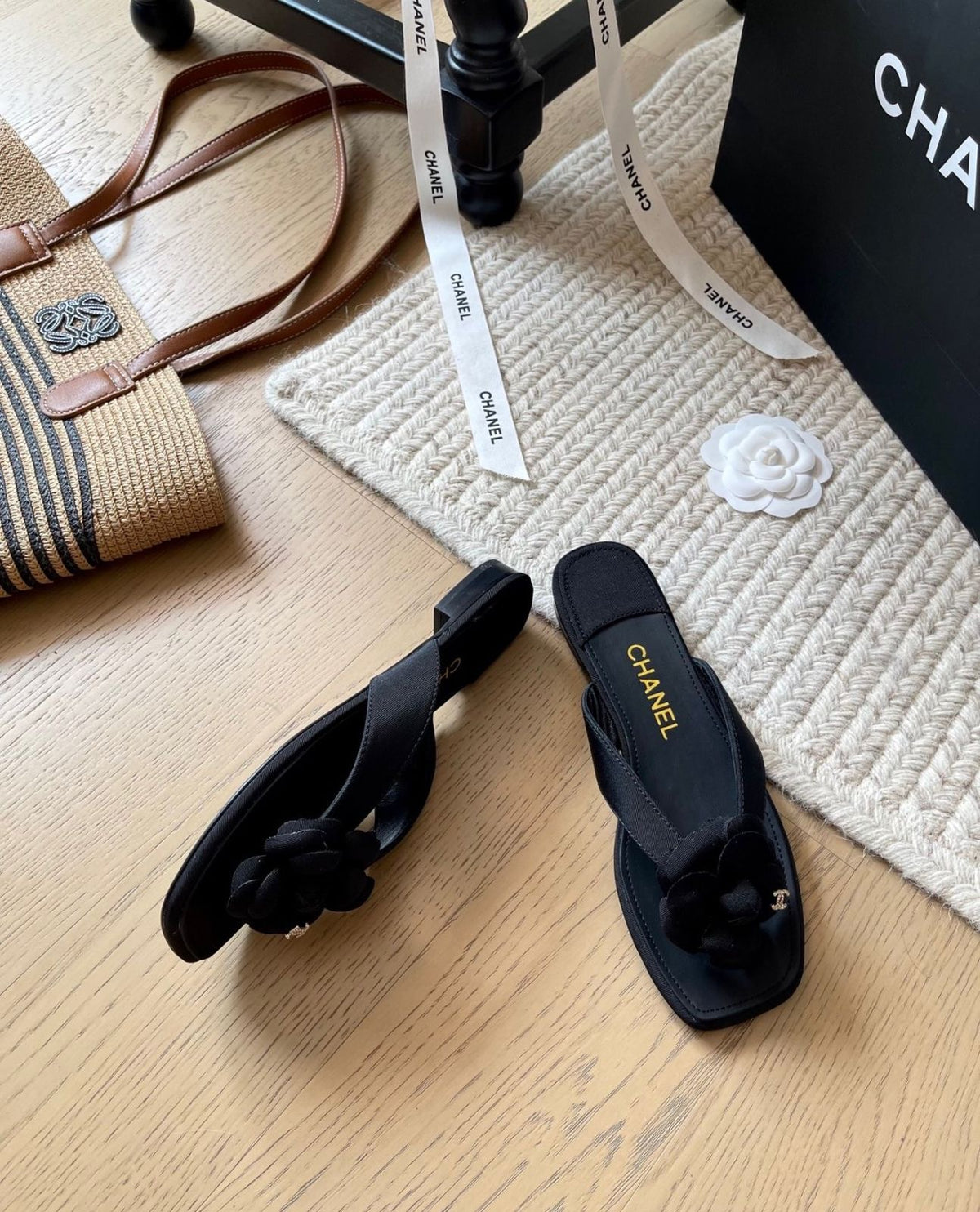 Channel black flat thong sandals featuring a dimensional Camellia flower accent on the strap