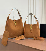 The Saint Laurent Le 5 à 7 Supple Large shoulder bag suede features the iconic gold-tone Cassandre hook closure and a relaxed, slouchy silhouette