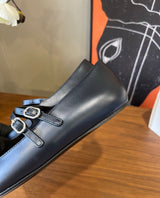 black Chanel Mary Jane flats featuring smooth leather bodies, double buckled straps, and grosgrain cap toes accented with an embroidered CC logo