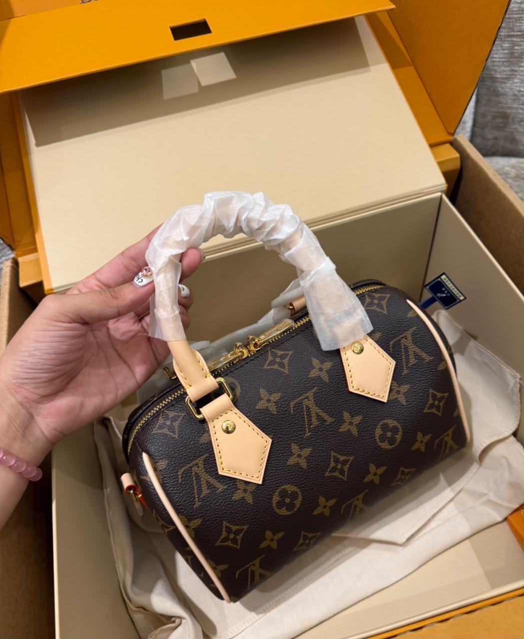 Louis Vuitton Speedy Bandoulière in Monogram canvas features signature cowhide leather trim and protective packaging wrapped around the top handle