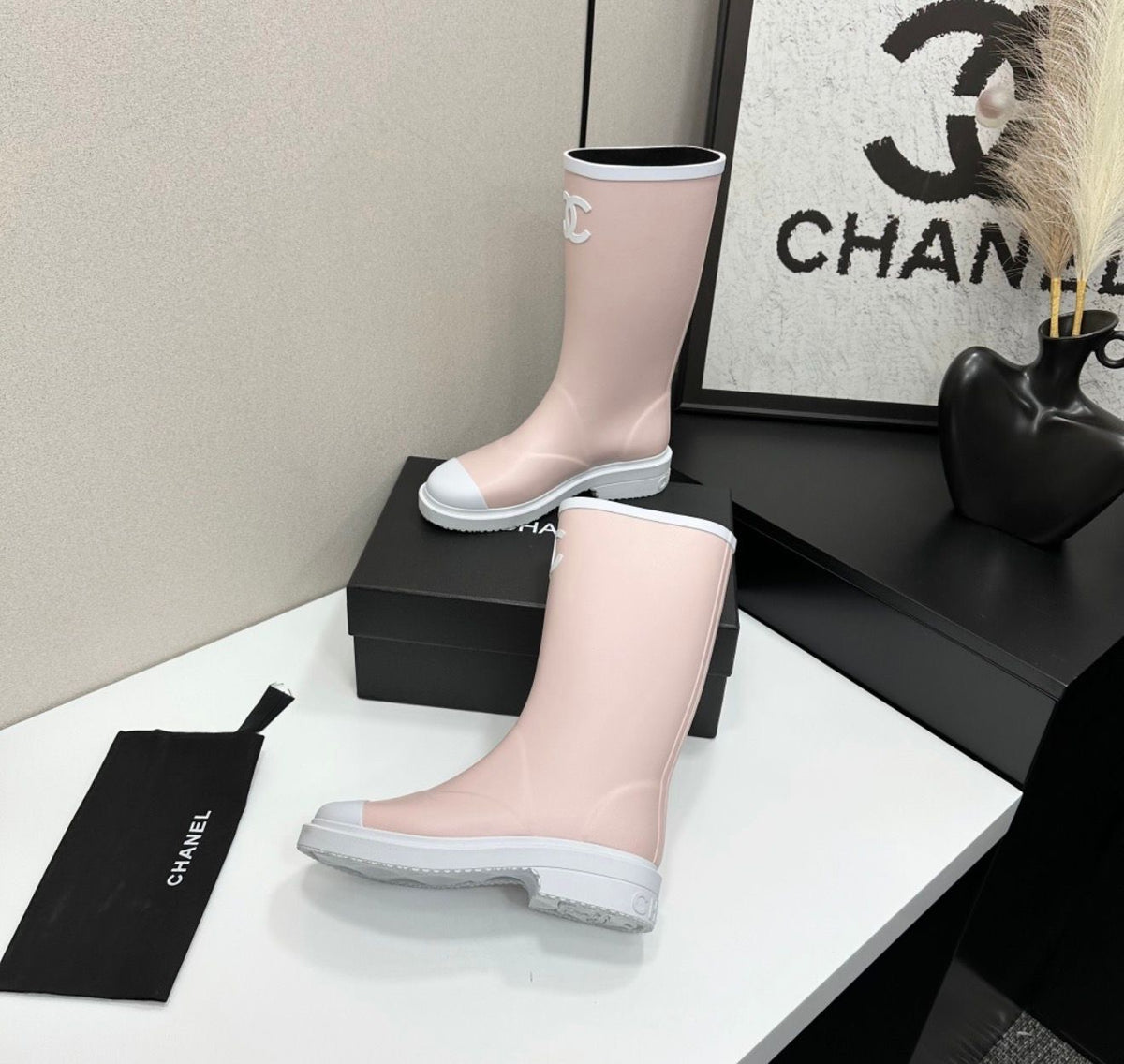 light pink and white Chanel Caoutchouk CC high rubber rain boots featuring the iconic interlocking CC logo on the shaft.