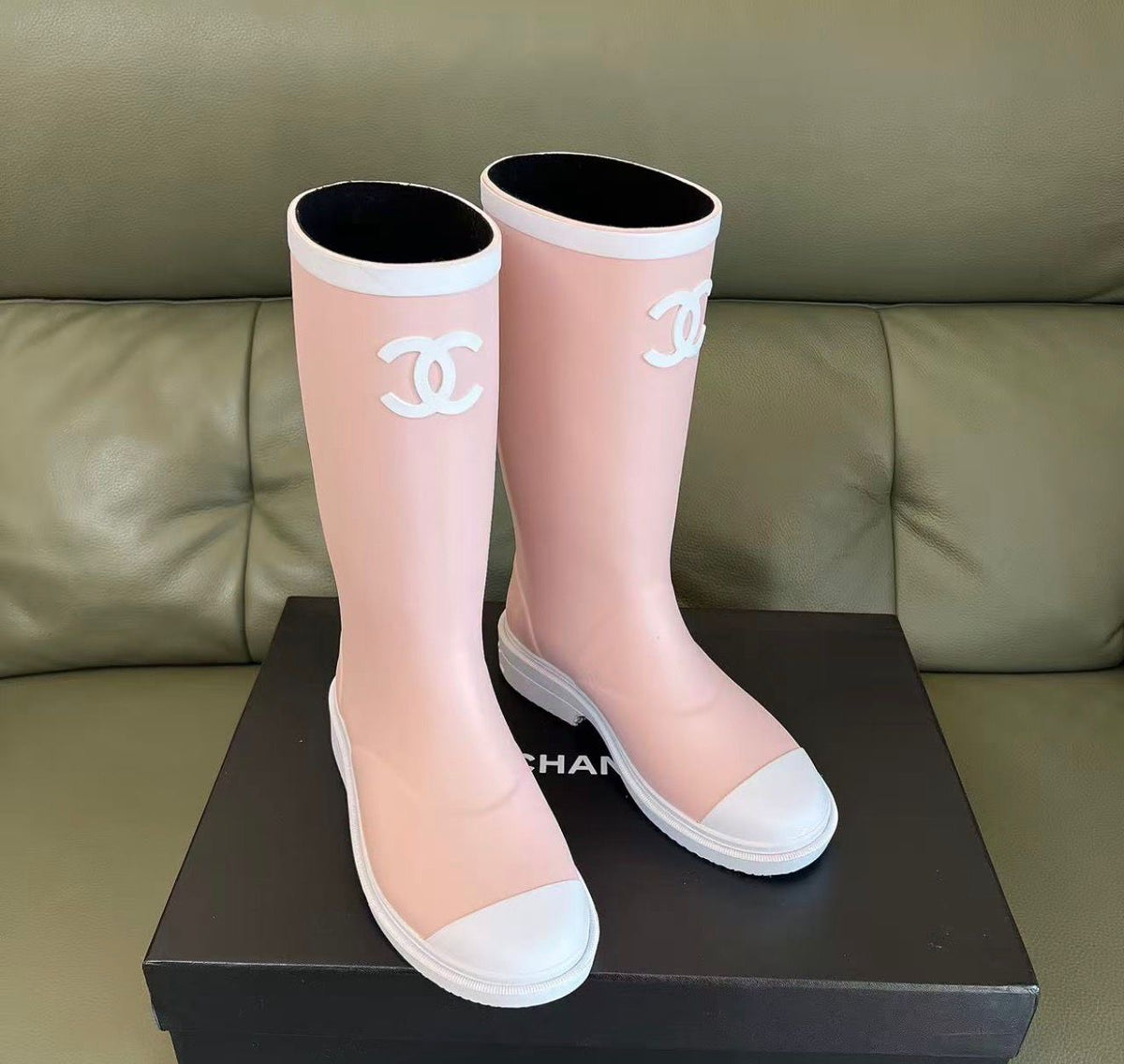 light pink and white Chanel Caoutchouk CC high rubber rain boots featuring the iconic interlocking CC logo on the shaft.