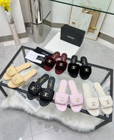 Channel flat slide slipper adorned with the iconic gold-tone Chanel CC logo
