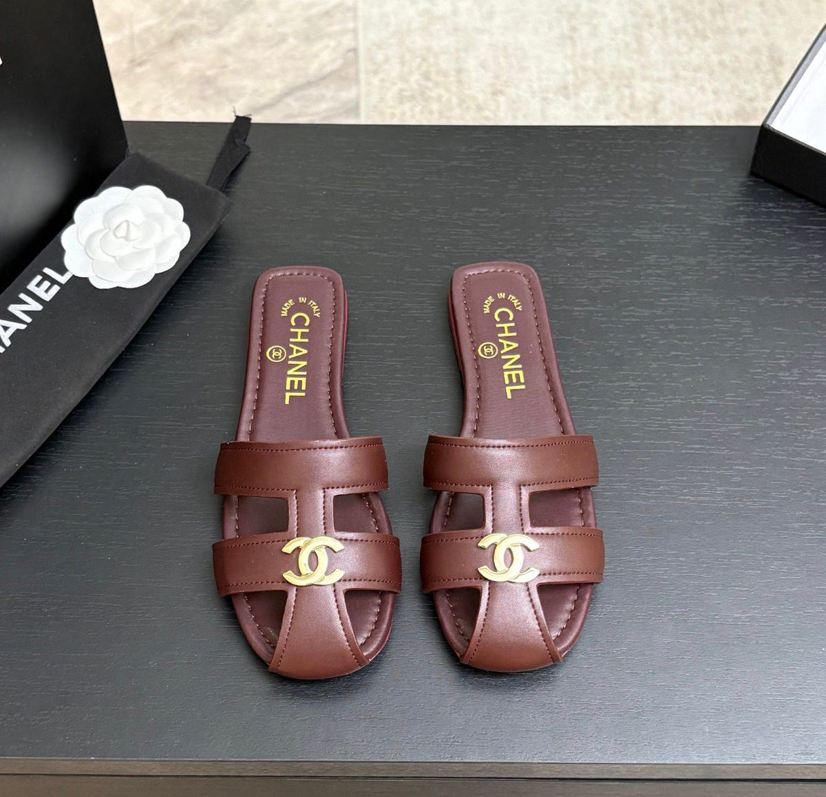 lambskin Chanel flat mules featuring a polished gold-tone CC logo on the cutout strap