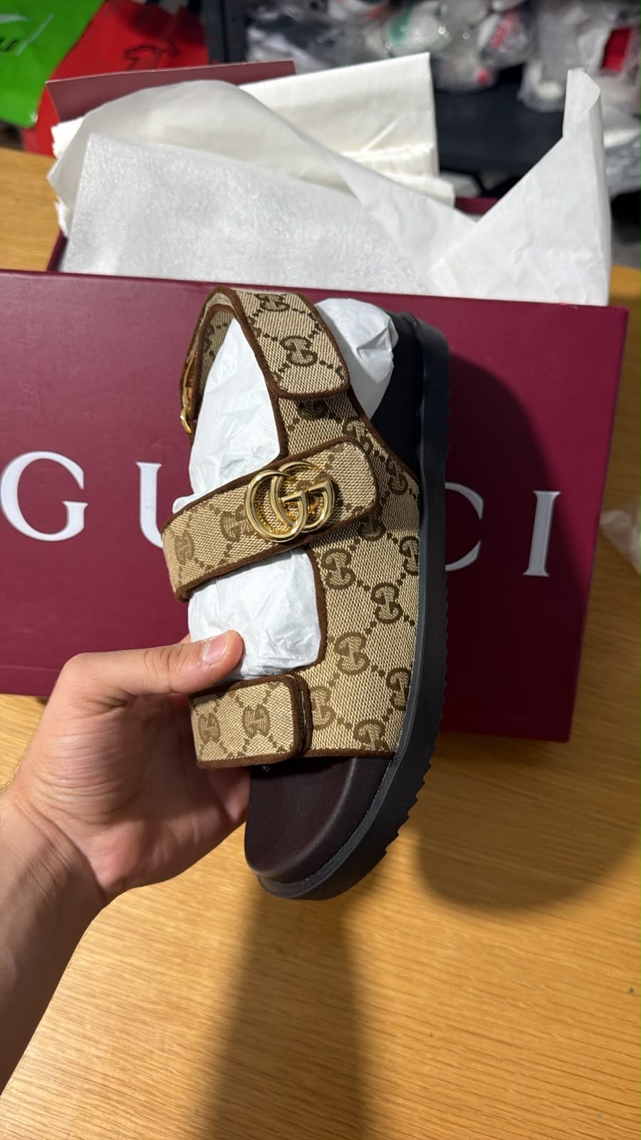 Gucci GG Supreme canvas flat sandals featuring the signature gold-toned Interlocking G hardware and adjustable velcro straps.