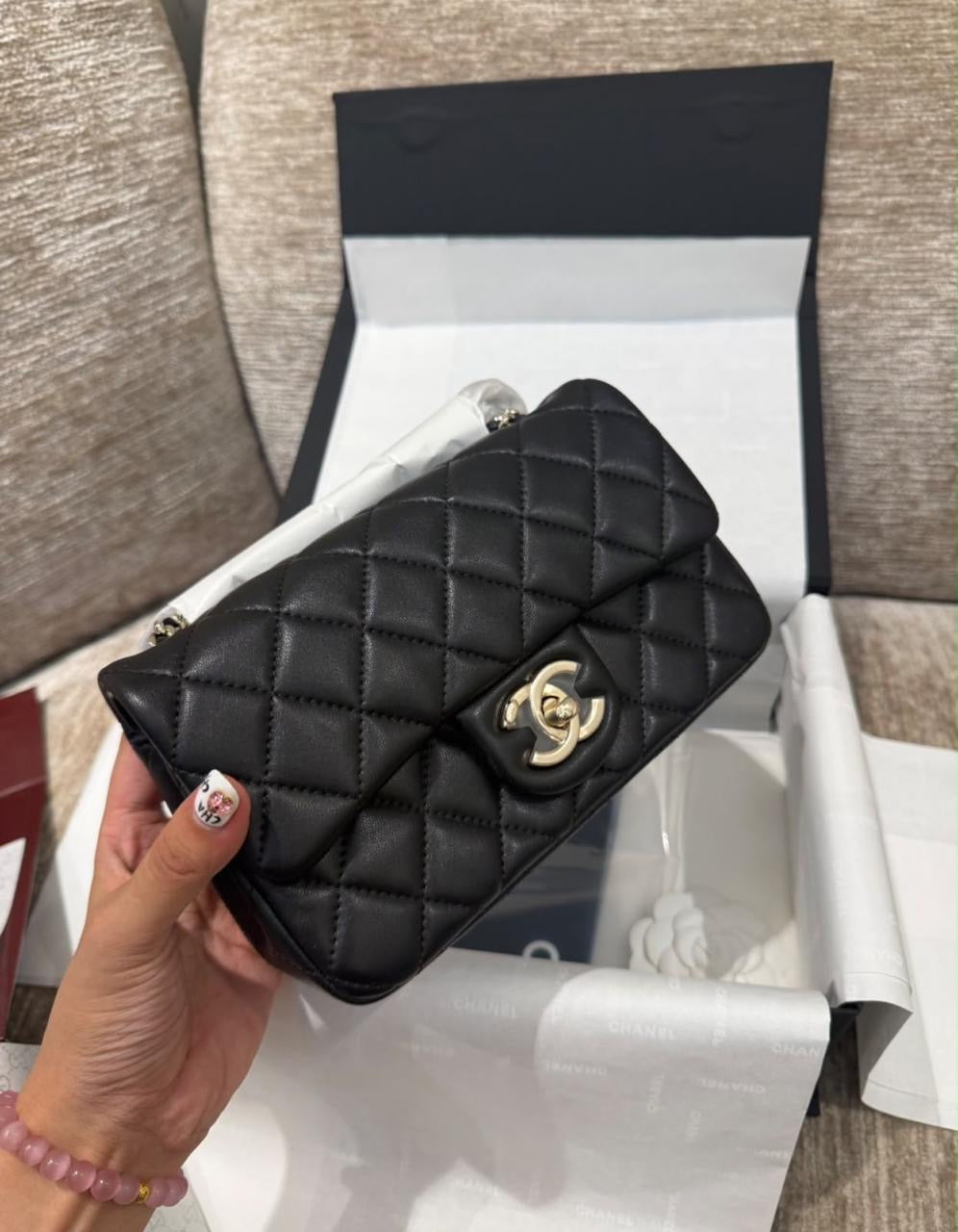 lambskin Chanel Mini Classic Flap Bag accented with gleaming gold-tone CC hardware