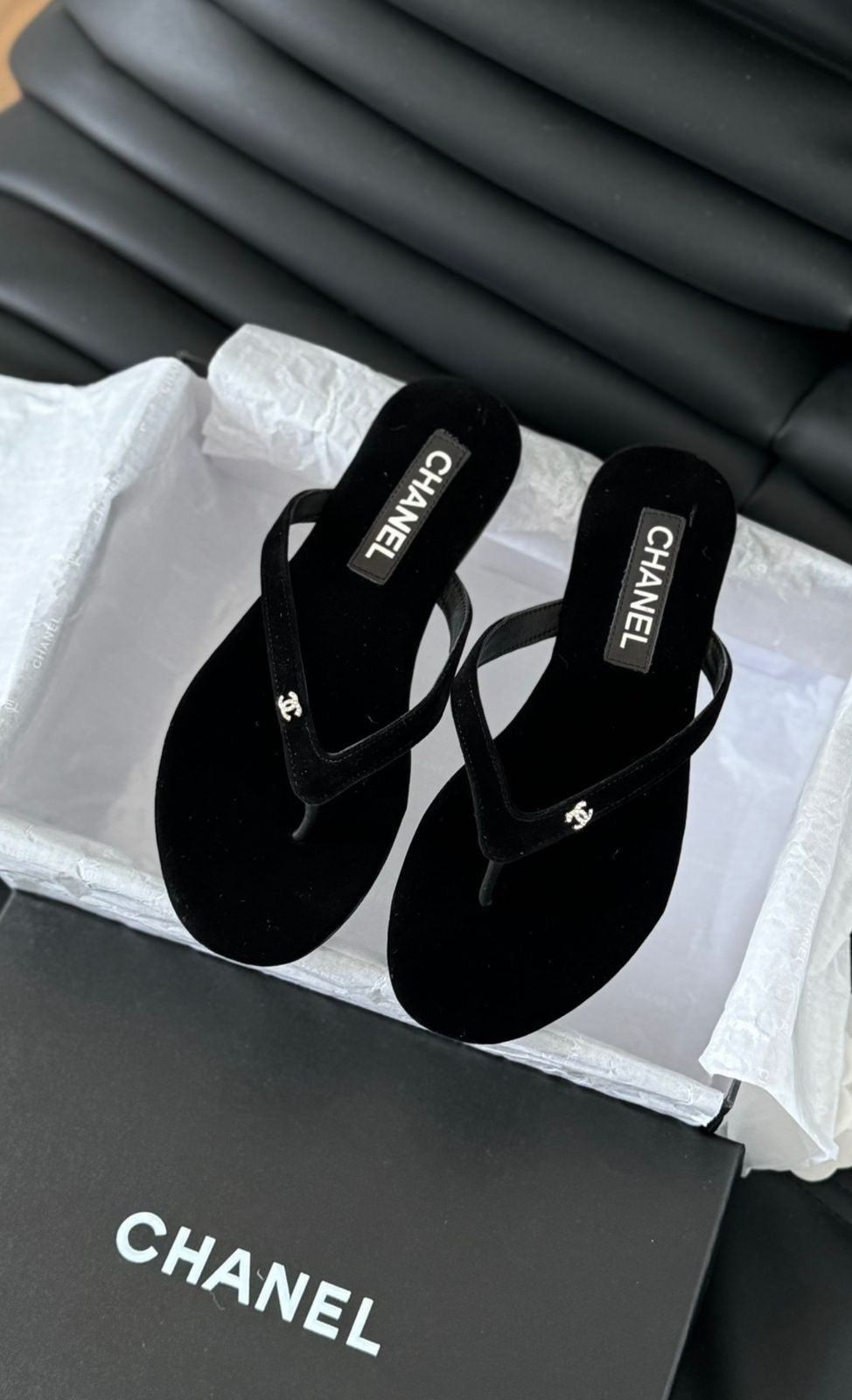 black velvet Chanel flip-flop sandals featuring a small, crystal-accented CC logo on the strap