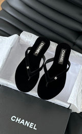 black velvet Chanel flip-flop sandals featuring a small, crystal-accented CC logo on the strap