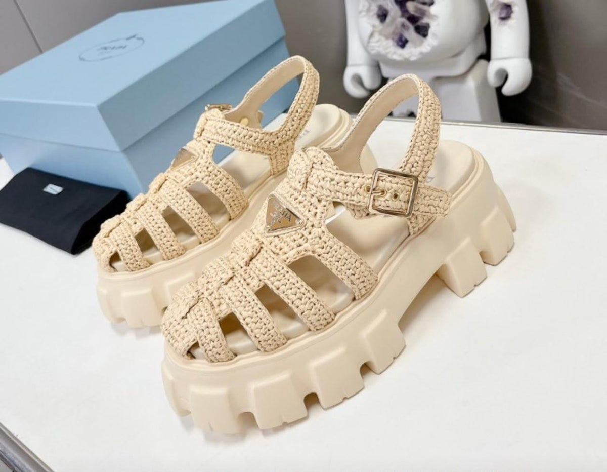 Prada Monolith crochet cage sandals, featuring a chunky lug sole and a woven, raffia-effect upper accented with the brand's signature metal triangle logo.( from 35-to 42)