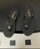 black leather Chanel thong flip-flop sandals featuring gold-tone interlocking CC logo hardware on the straps