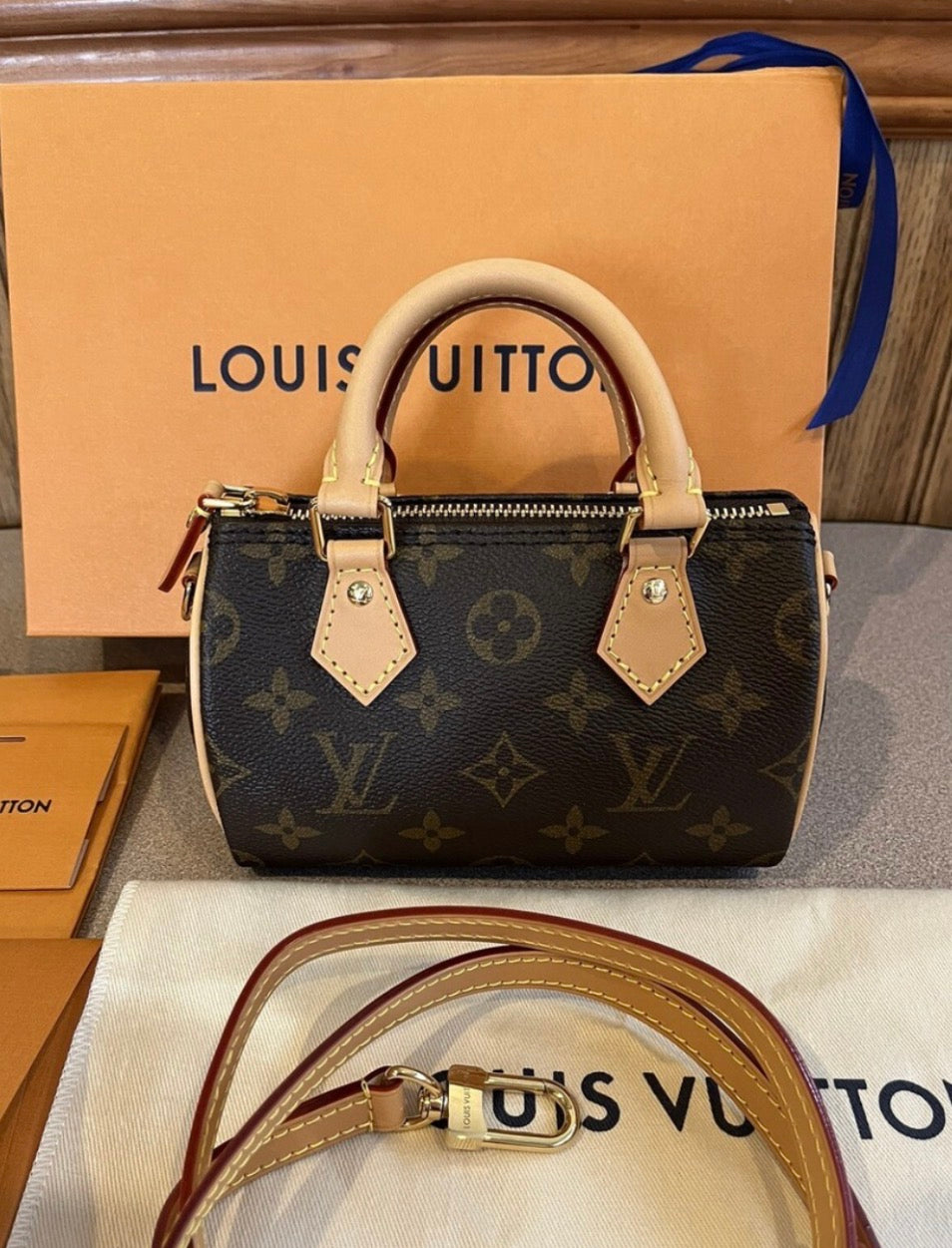 Louis Vuitton Speedy Bandoulière in Monogram canvas features signature cowhide leather trim and protective packaging wrapped around the top handle