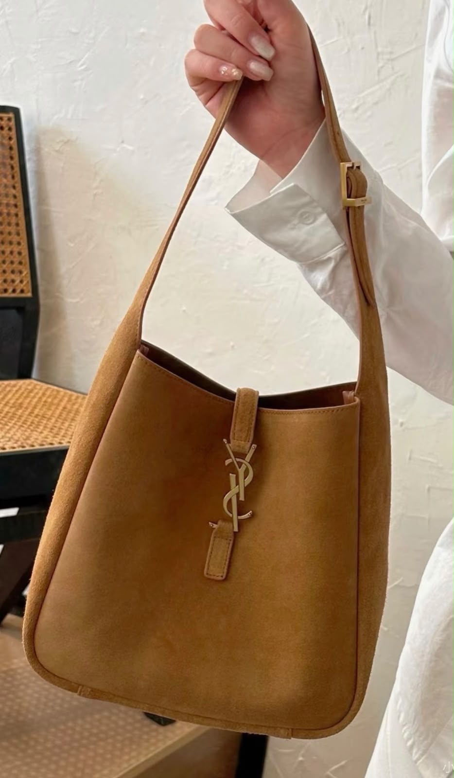 The Saint Laurent Le 5 à 7 Supple Large shoulder bag suede features the iconic gold-tone Cassandre hook closure and a relaxed, slouchy silhouette