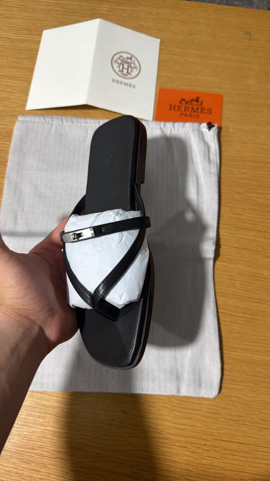 black calfskin Hermès Miss sandals featuring an interlaced thong silhouette and a mini version of the iconic palladium-plated Kelly buckle