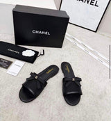 Chanel sheer mesh flat mules featuring a delicate black bow accented with the iconic CC logo