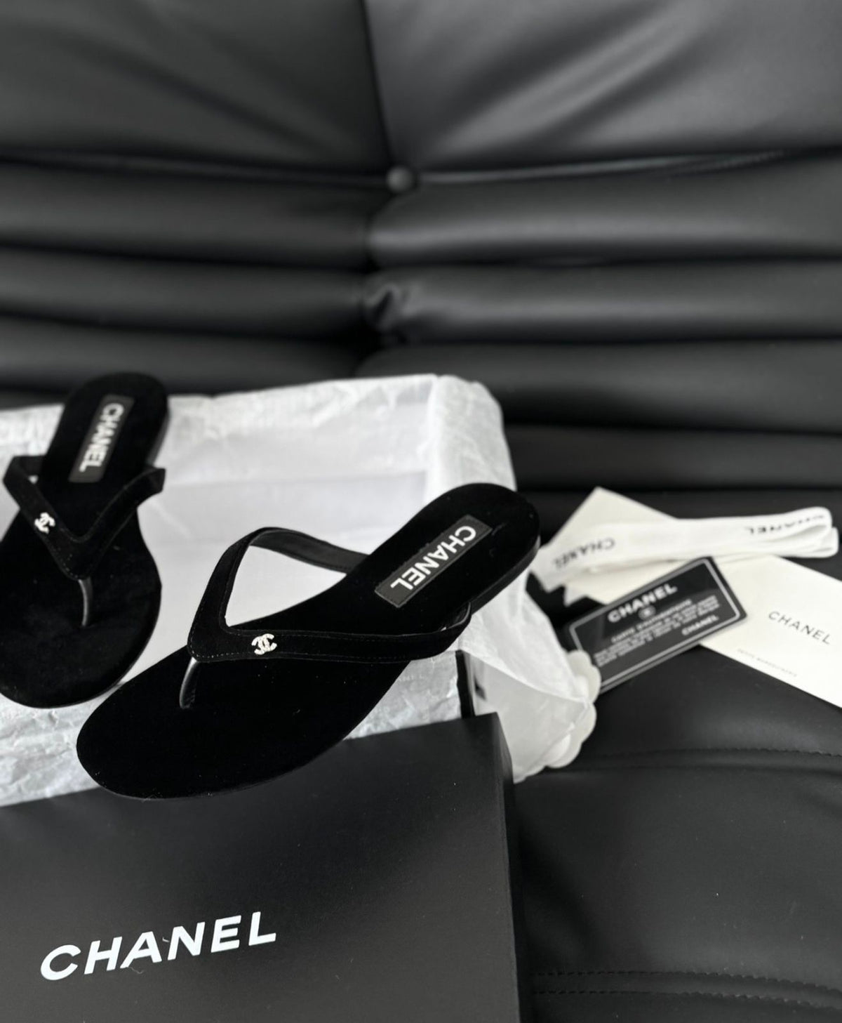 black velvet Chanel flip-flop sandals featuring a small, crystal-accented CC logo on the strap