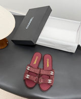 black suede Chanel flat mules featuring double Velcro straps with gold-tone hardware and crystal CC embellishments