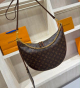 Louis Vuitton Loop Hobo in Monogram canvas with its distinctive half-moon silhouette accented by a gleaming gold-tone chain