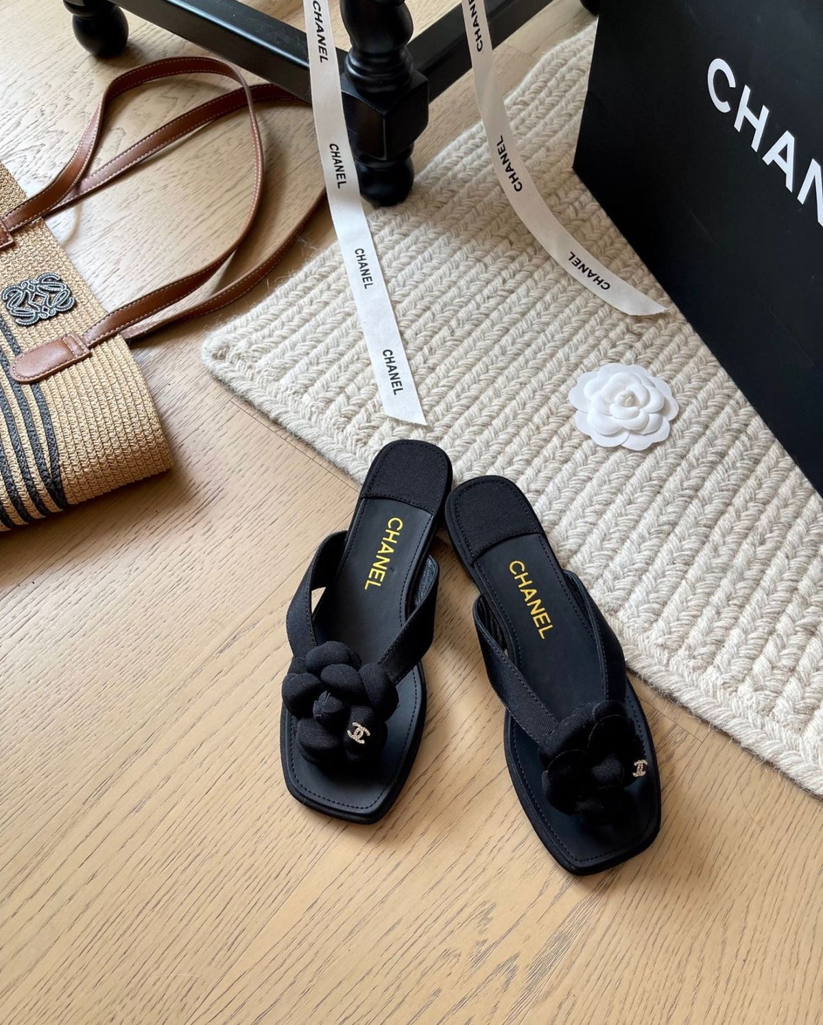 Channel black flat thong sandals featuring a dimensional Camellia flower accent on the strap