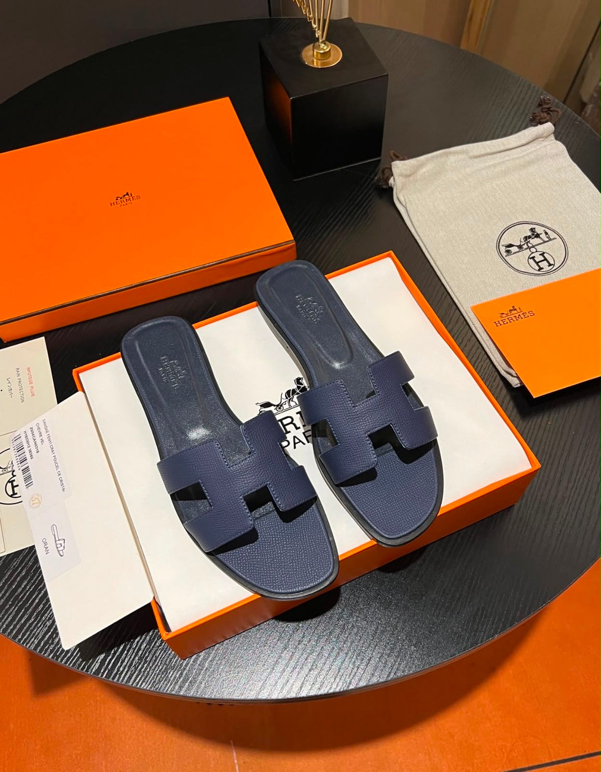 Hermès Oran sandals feature the iconic "H" cut-out design in textured calfskin leather
