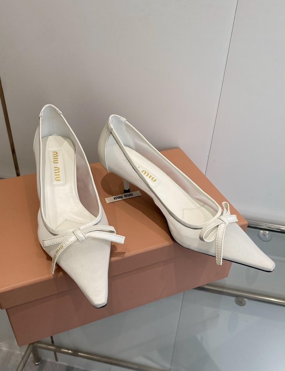 white Miu Miu mesh kitten-heel pumps feature a sharp pointed toe accented with a delicate matching bow