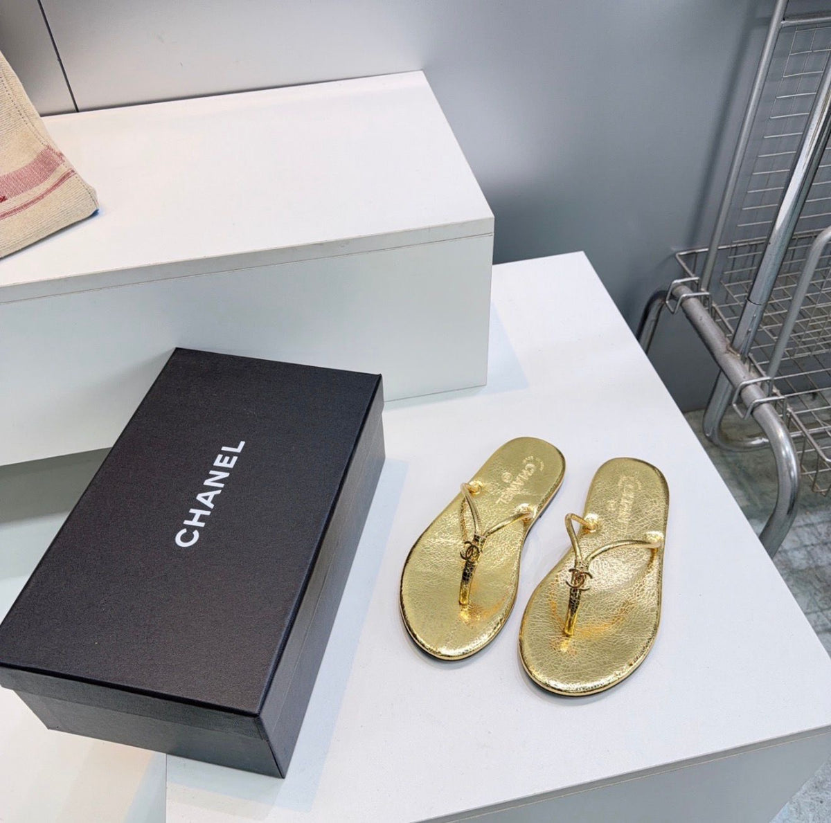 black leather Chanel thong flip-flop sandals featuring gold-tone interlocking CC logo hardware on the straps