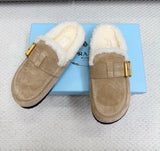 These cozy Prada suede shearling mules feature a soft, plush white shearling lining and an adjustable gold-tone side buckle