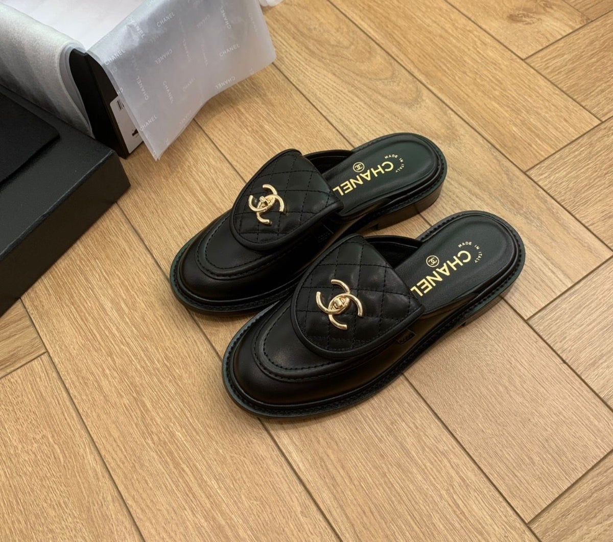 Channel Lambskin Quilted CC Turnlock Mules in black lambskin leather featuring a quilted flap front tongue and gold-tone CC metal turnlock logo