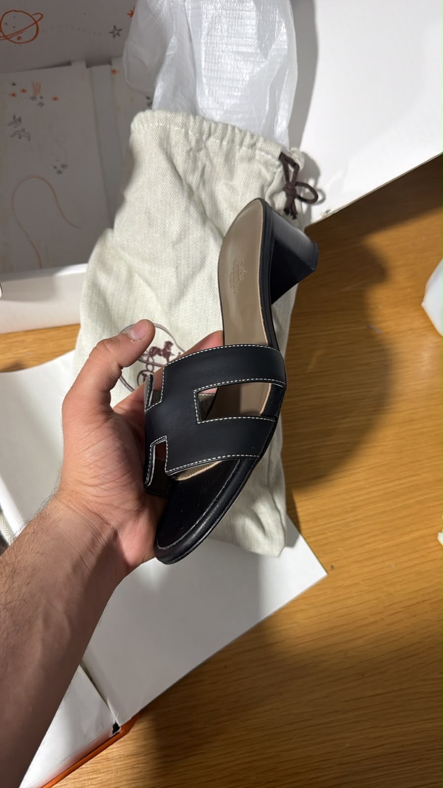 black Hermès Oasis sandals featuring the signature 'H' cut-out strap and a comfortable block heel.