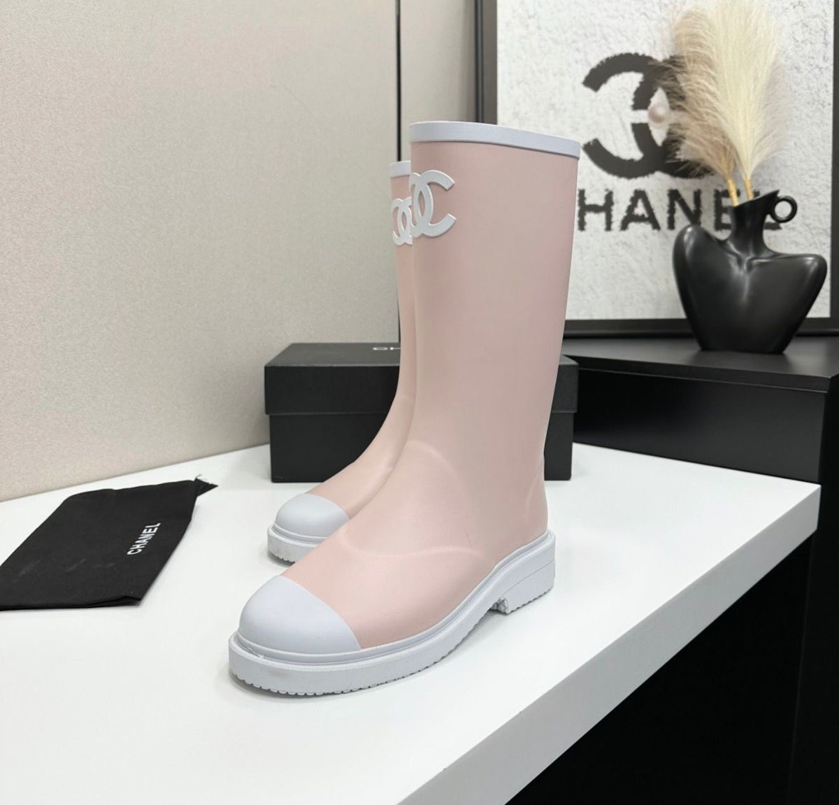 light pink and white Chanel Caoutchouk CC high rubber rain boots featuring the iconic interlocking CC logo on the shaft.