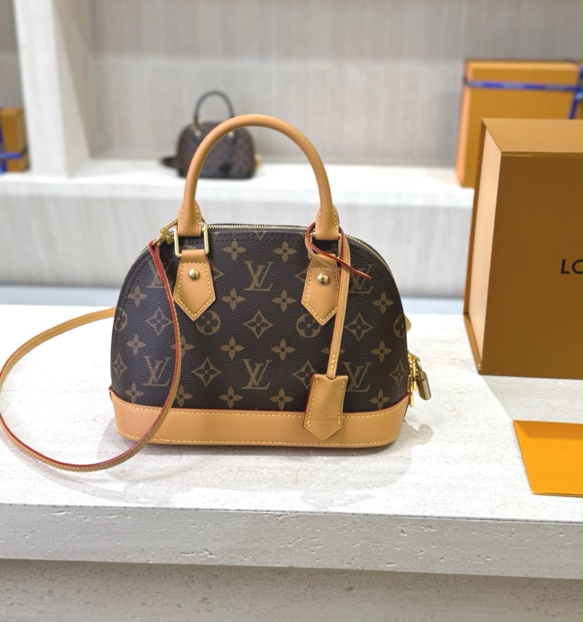 Louis Vuitton Alma BB handbag in signature Monogram canvas with natural cowhide leather trim and a detachable shoulder strap