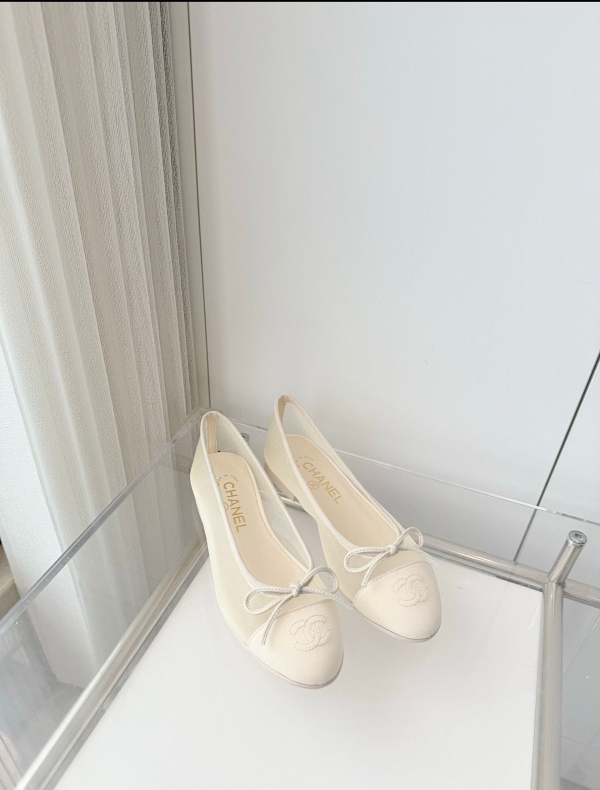 quilted leather ballet flats by Chanel, featuring the iconic interlocking CC logo and a delicate bow on the toe