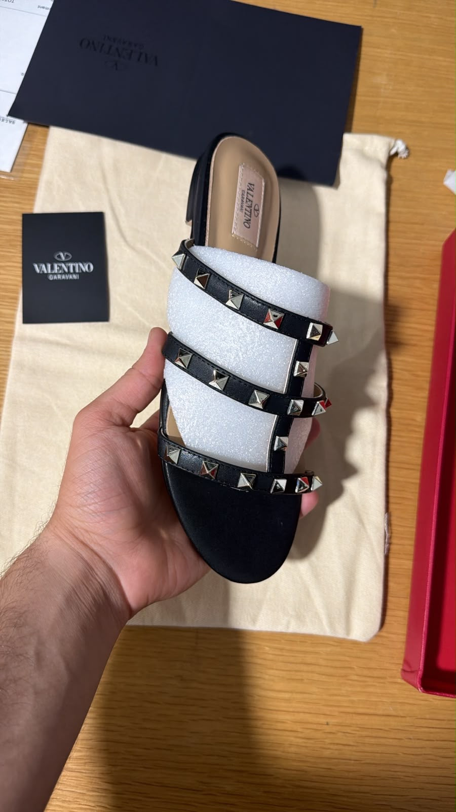 black Valentino Garavani Rockstud flat slide sandals featuring a multi-strap design accented with signature pyramid studs.