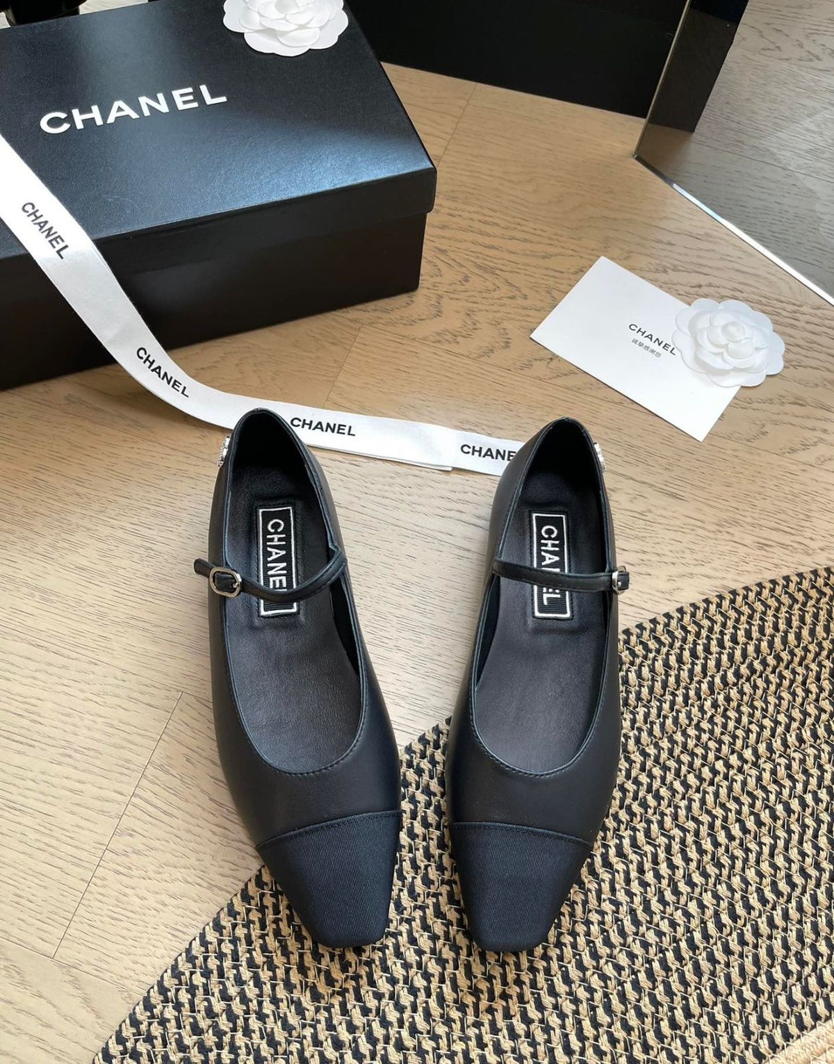 Channel black Mary Jane flats featuring a slim strap with a buckle and a contrasting grosgrain cap-toe