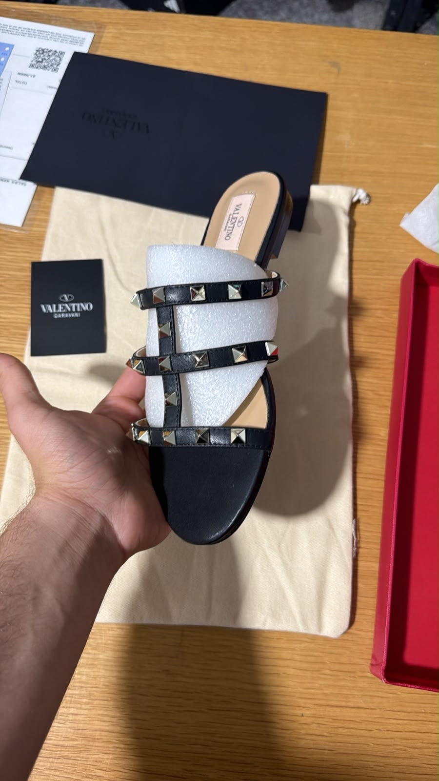 black Valentino Garavani Rockstud flat slide sandals featuring a multi-strap design accented with signature pyramid studs.