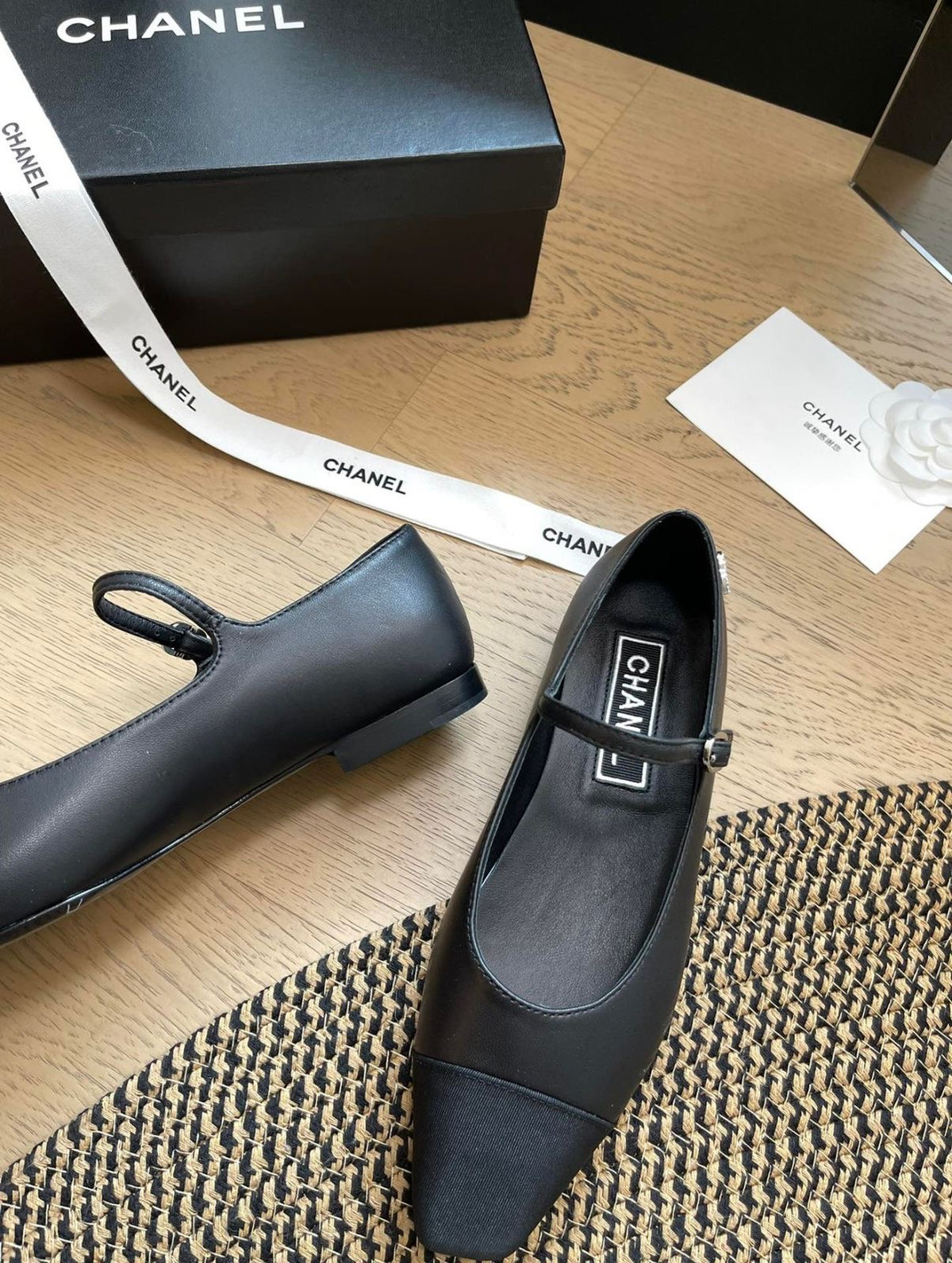 Channel black Mary Jane flats featuring a slim strap with a buckle and a contrasting grosgrain cap-toe