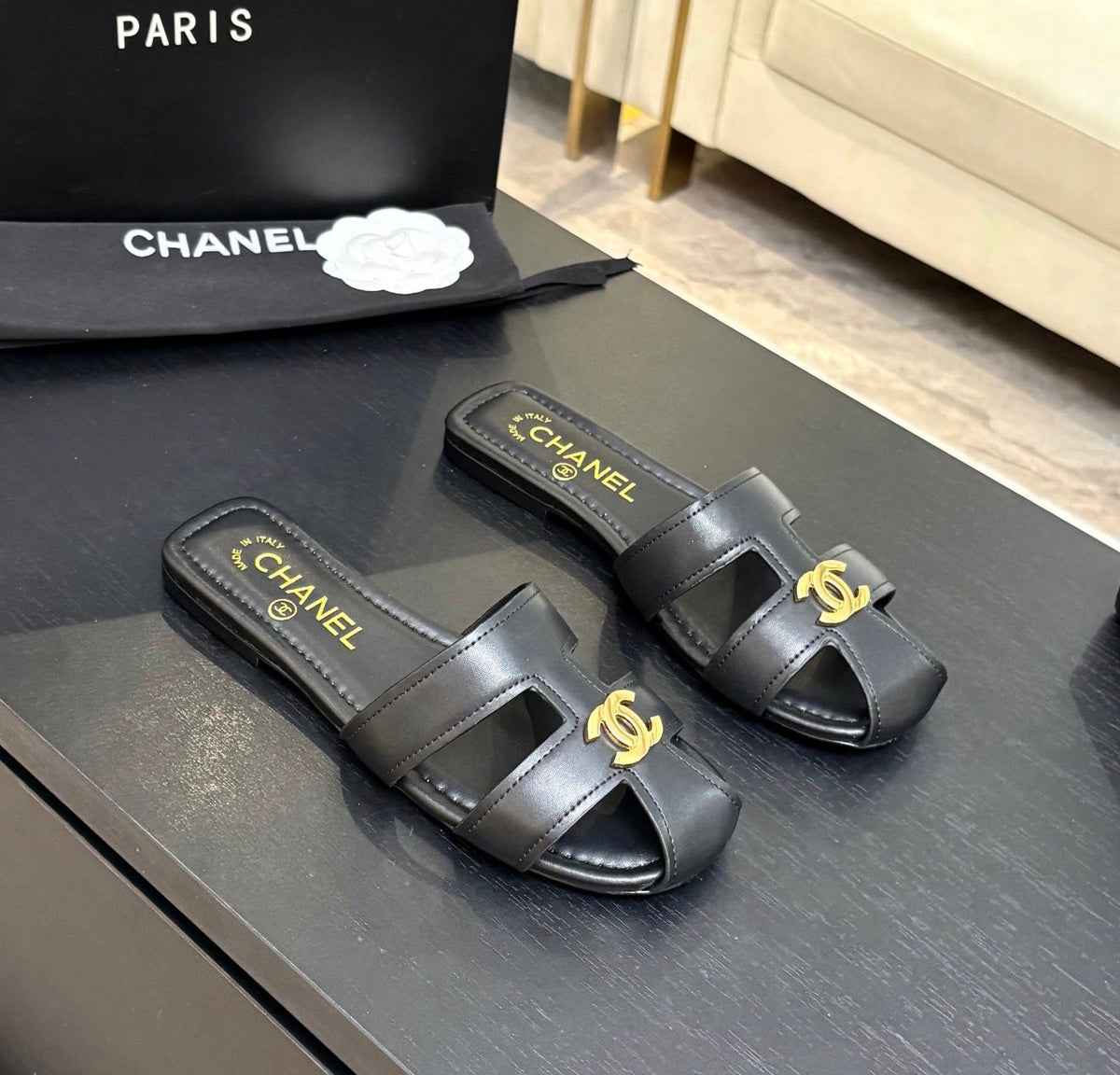lambskin Chanel flat mules featuring a polished gold-tone CC logo on the cutout strap