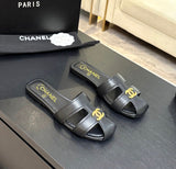 lambskin Chanel flat mules featuring a polished gold-tone CC logo on the cutout strap