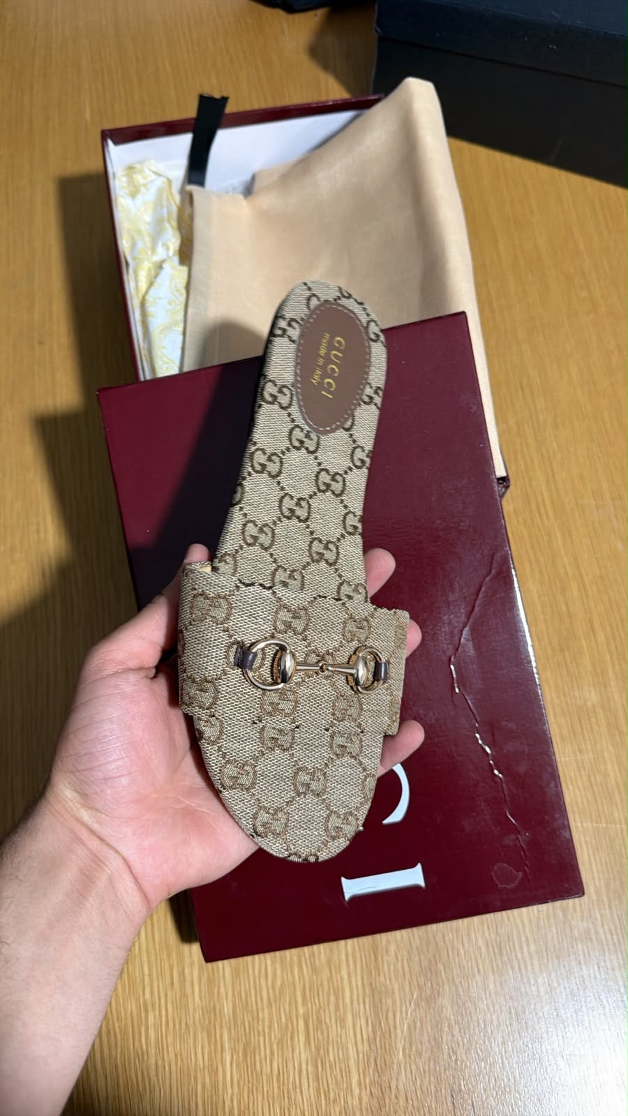 Gucci slide slipper crafted from beige and dark brown GG monogram canvas and finished with a classic gold-toned horsebit detail.