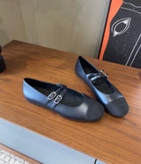 black Chanel Mary Jane flats featuring smooth leather bodies, double buckled straps, and grosgrain cap toes accented with an embroidered CC logo